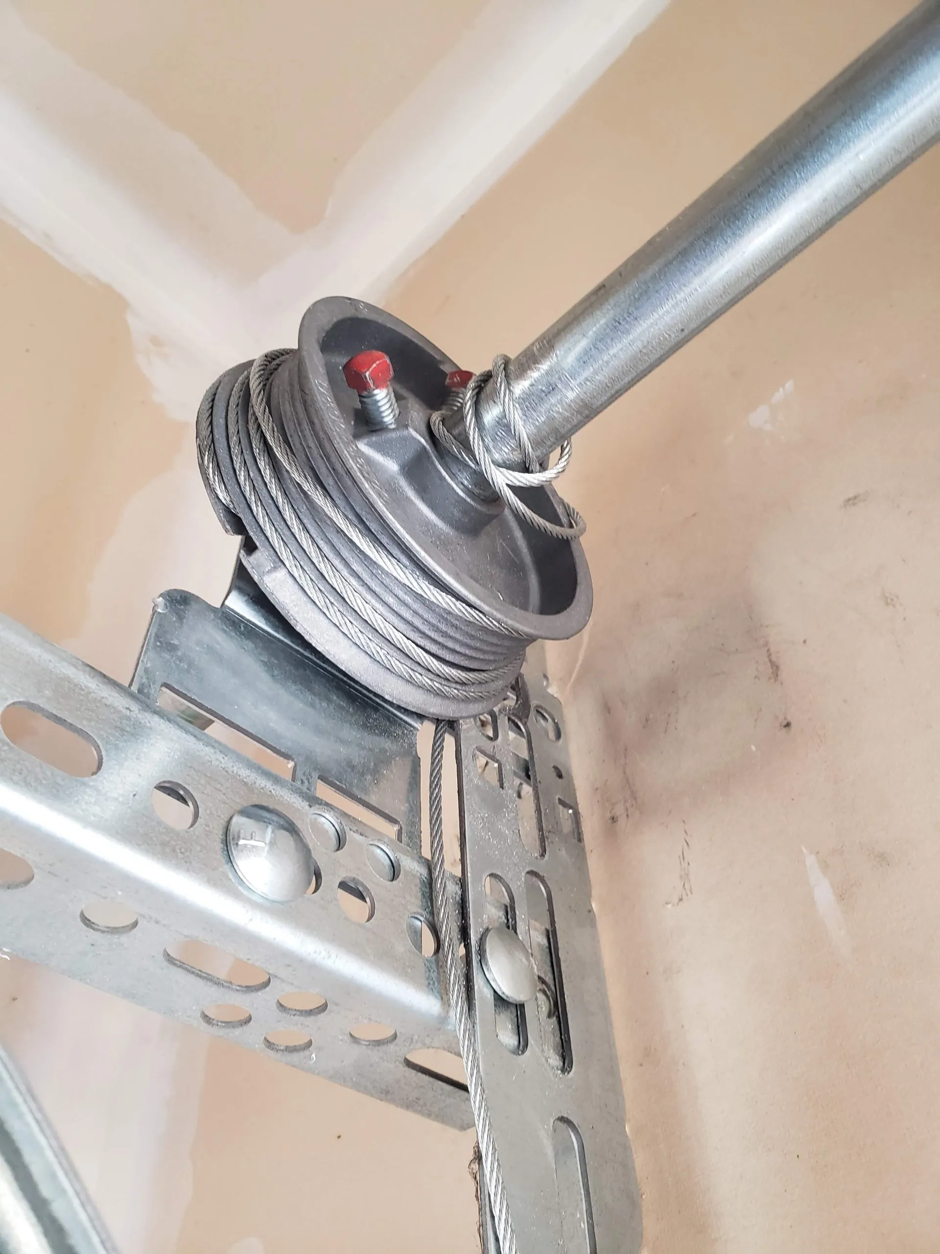 Garage door lifting cable wound around its drum